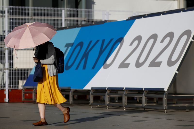 A woman walks past Tokyo 2020 Olympic Games signage at