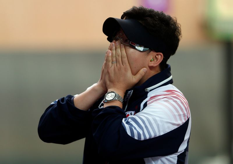 South Korea’s Jin Jong-oh covers his face after winning the