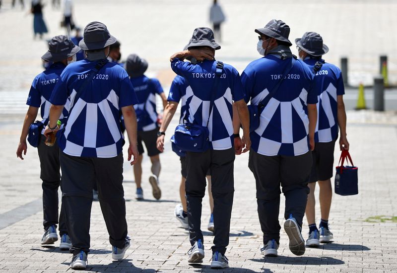 FILE PHOTO: Tokyo 2020 Olympic Games’ volunteers walk on a
