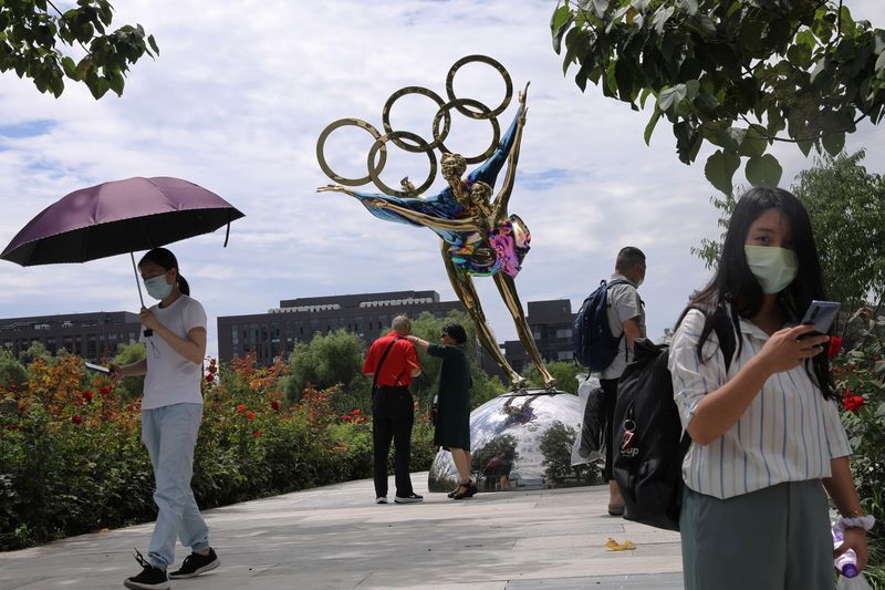 Visitors are seen next to a sculpture featuring skates outside