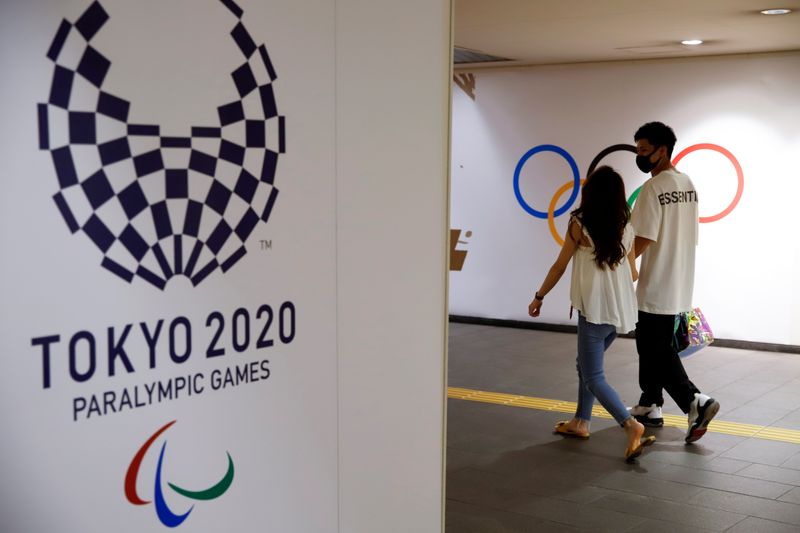 People walk by the Tokyo 2020 Paralympics logo at a