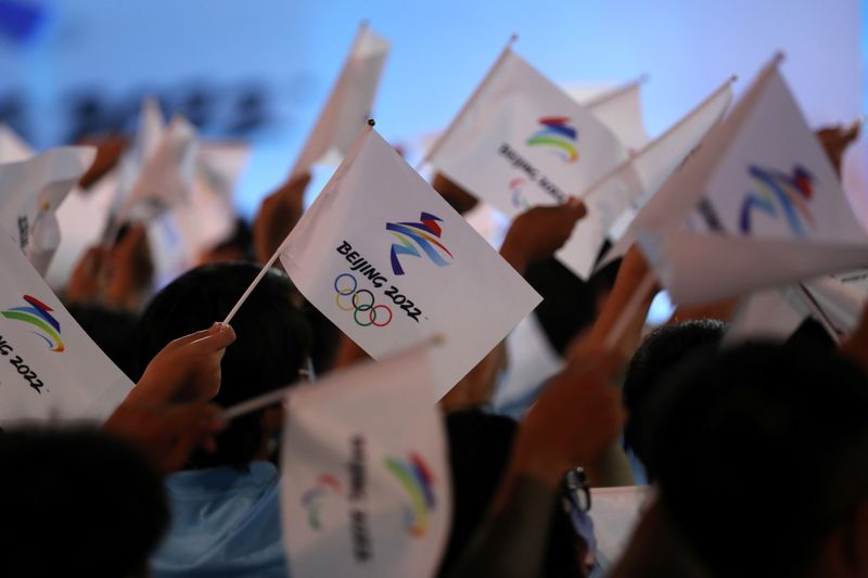 Attendees wave flags with the emblem of the Beijing 2022