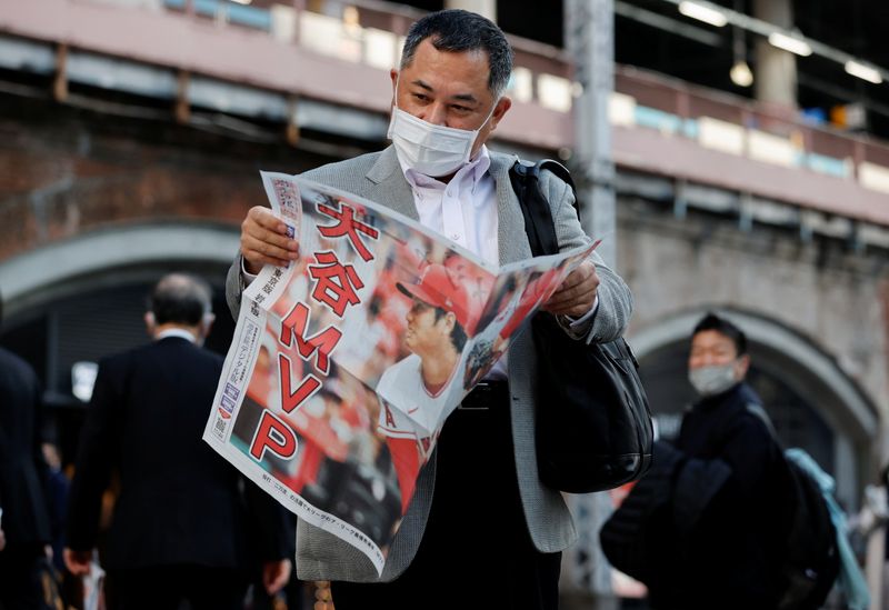 A man reads an extra edition of a newspaper, reporting