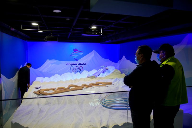 Staff members work near the emblem for Beijing 2022 Winter