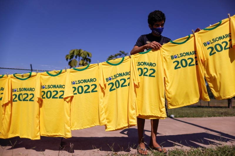 A boy hangs up t-shirts with the name of Brazilian