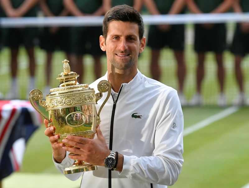 FILE PHOTO: Serbia’s Novak Djokovic poses with the trophy as