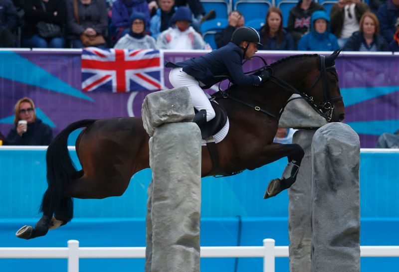 Australia’s Andrew Hoy clears a fence during the Eventing jumping