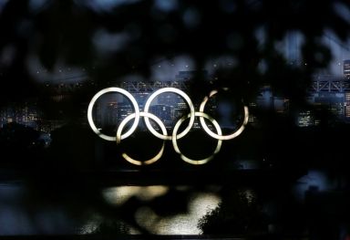 The giant Olympic rings are seen through a tree in
