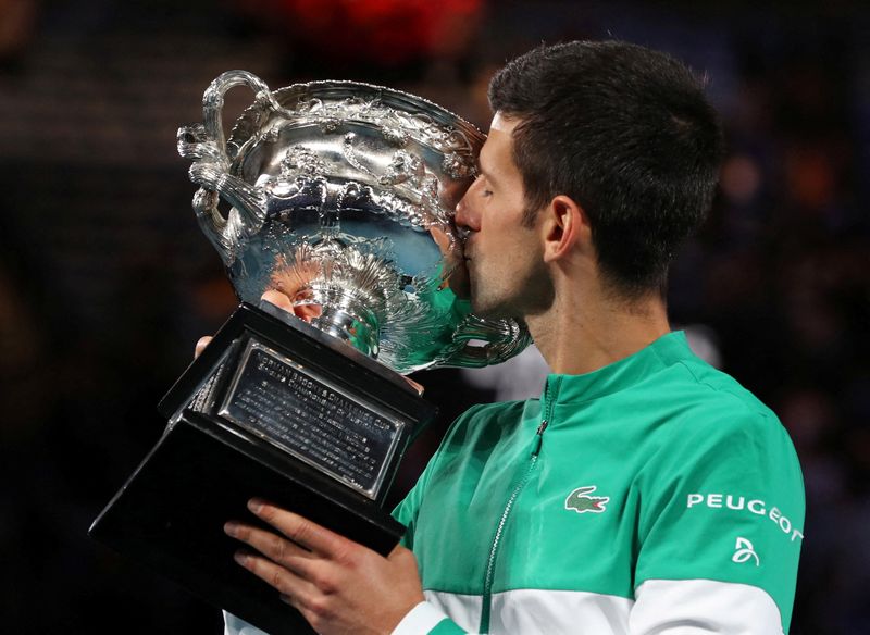 FILE PHOTO: Serbia’s Novak Djokovic celebrates with the trophy after