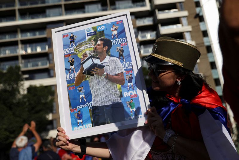 Supporters gather outside the hotel where Novak Djokovic is believed