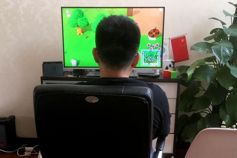 Chinese tutor Zhao plays the game “Animal Crossing” on Nintendo