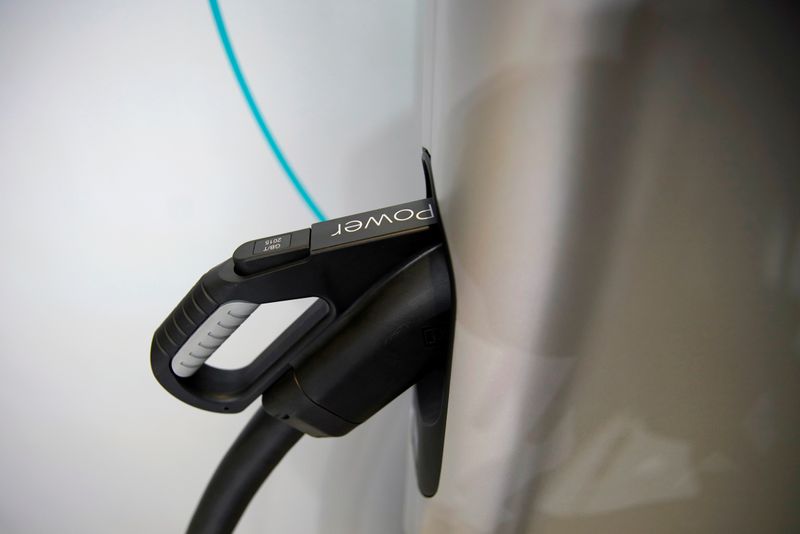 FILE PHOTO: Charging plug attached to an electric vehicle (EV)