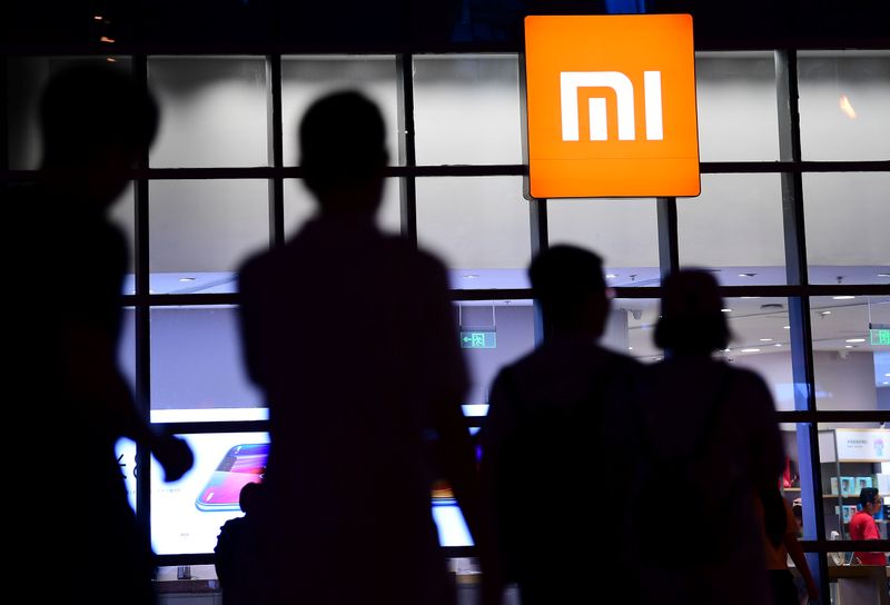 FILE PHOTO:  People walk past a Xiaomi store in