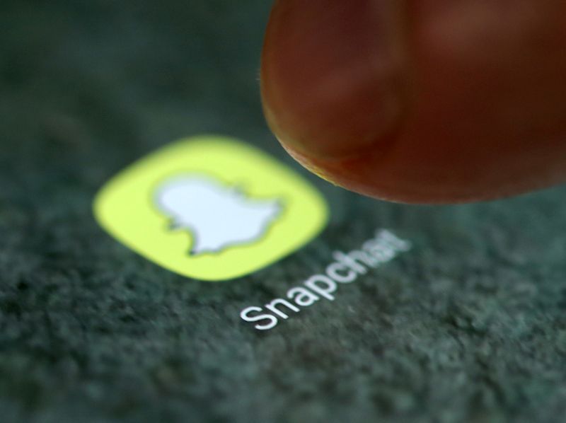 The Snapchat app logo is seen on a smartphone in