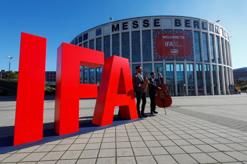 Musicians play on their instruments next to an IFA sign,
