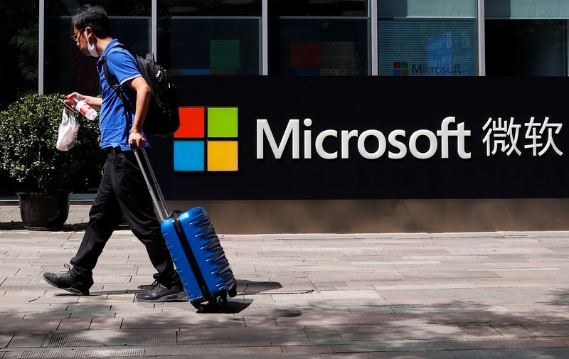A person walks past a Microsoft logo at the Microsoft
