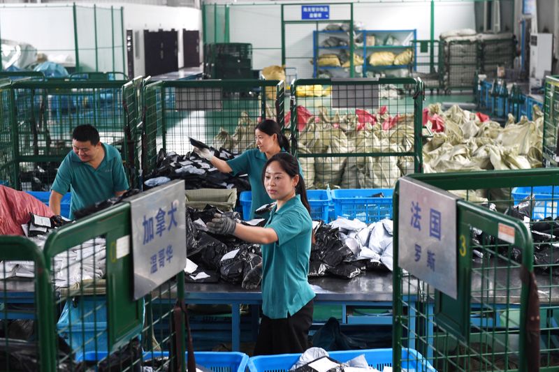 Workers sort international parcels at a cross-border e-commerce industrial park