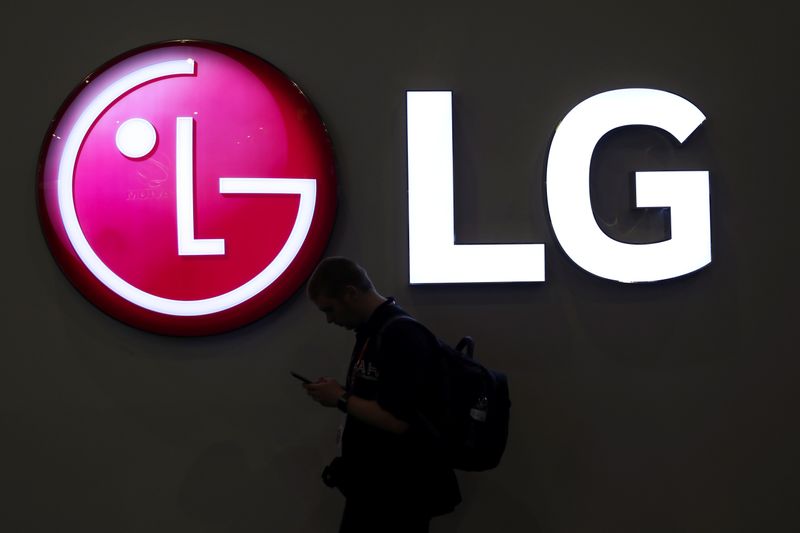 A man walks past an LG logo at the Mobile