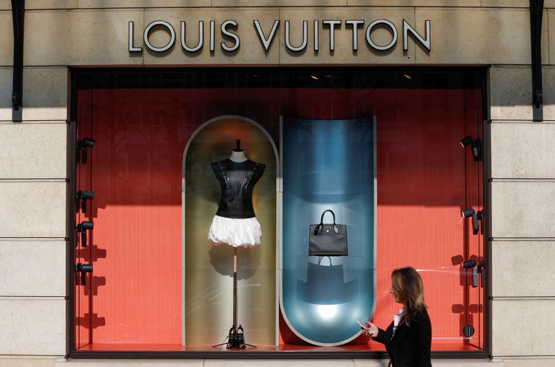 FILE PHOTO: A woman walks past a Louis Vuitton shop