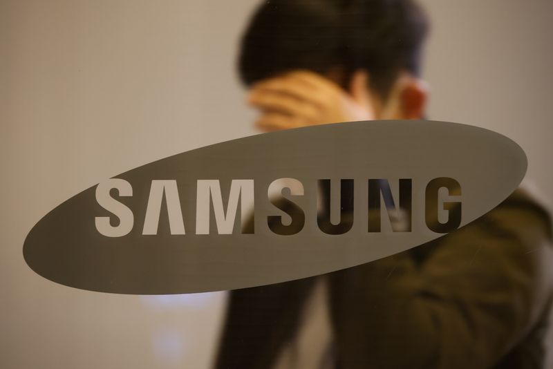 A man walks past the logo of Samsung at its
