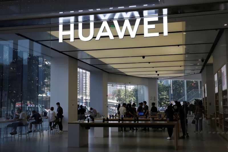 People are seen inside a Huawei store at a shopping