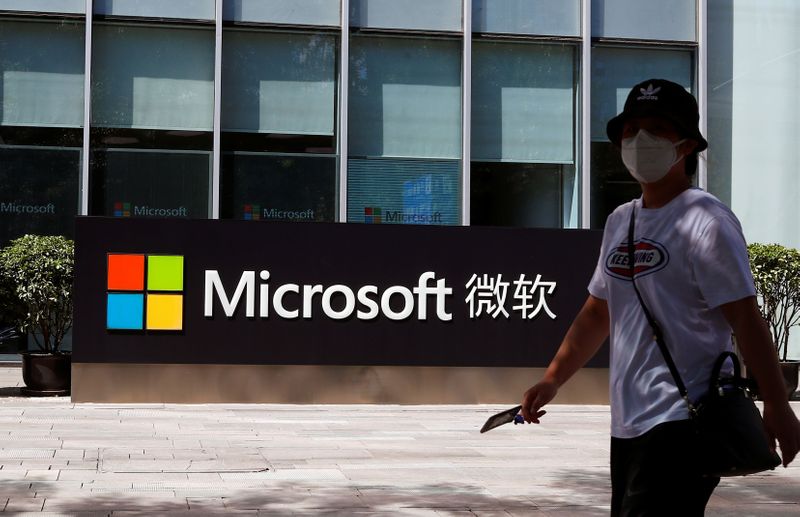 A person walks past a Microsoft logo at the Microsoft