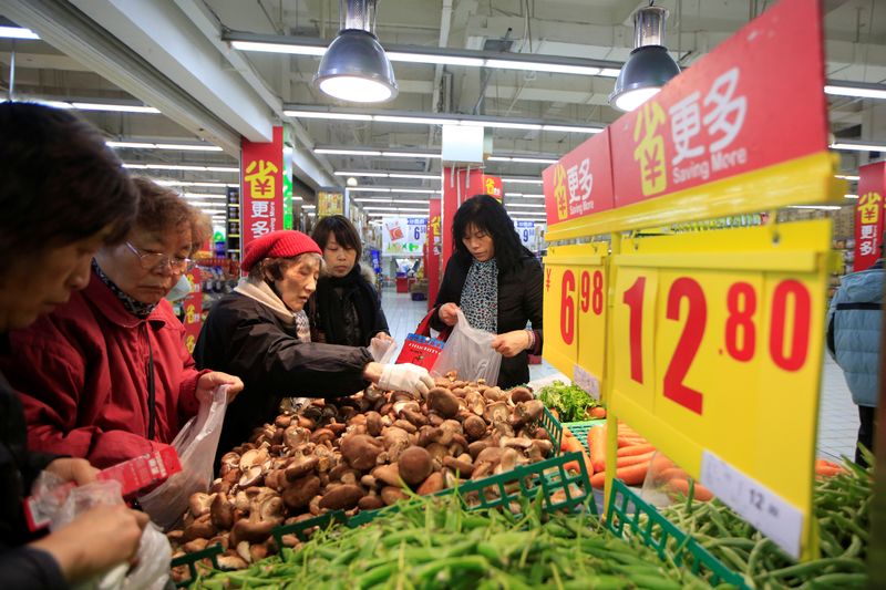 FILE PHOTO: Consumers choose vegetables at a supermarket in Shanghai