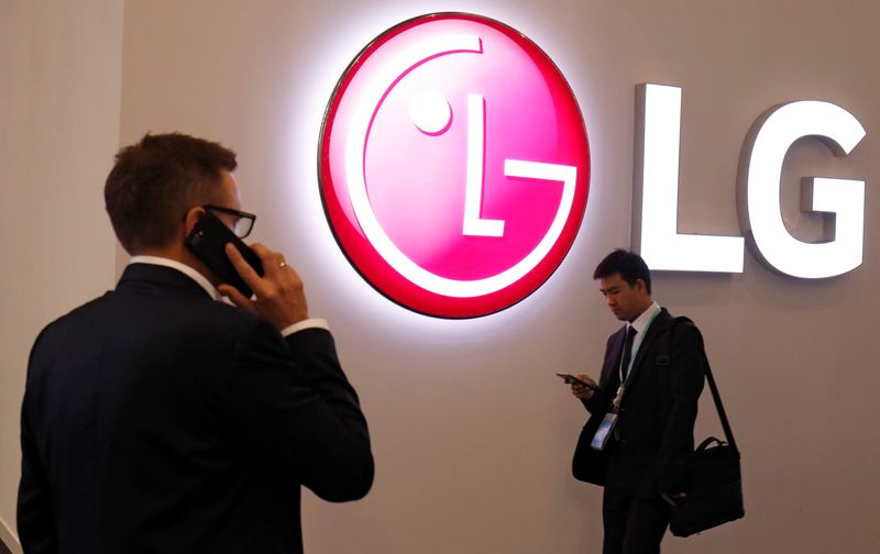 Visitors use their mobile phones next to LG booth during