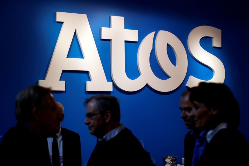 FILE PHOTO: People walk in front of the Atos company’s
