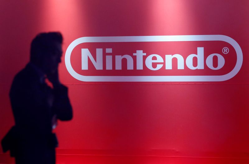 A man stands in front of Nintendo’s logo at the
