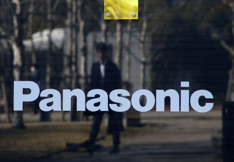 FILE PHOTO: A man is reflected on Panasonic Corp’s logo