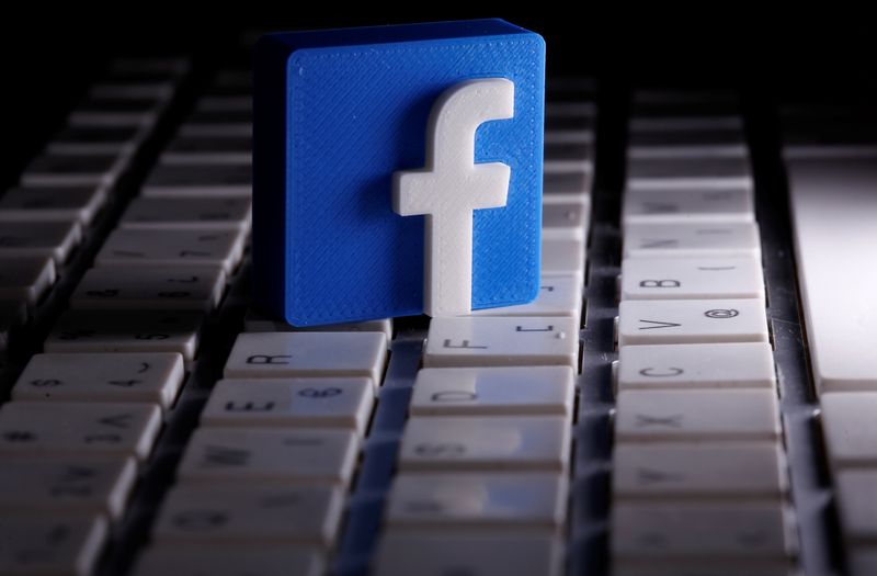 A 3D-printed Facebook logo is seen placed on a keyboard