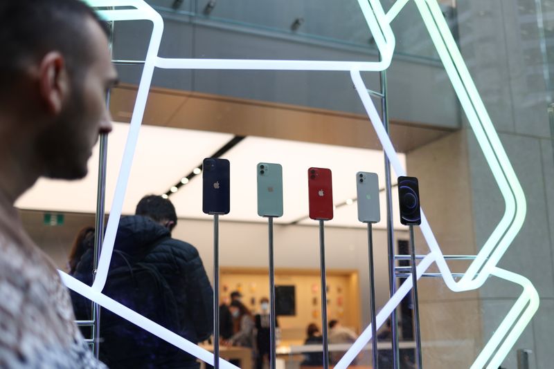 A shopper looks at an iPhone 12 display while waiting