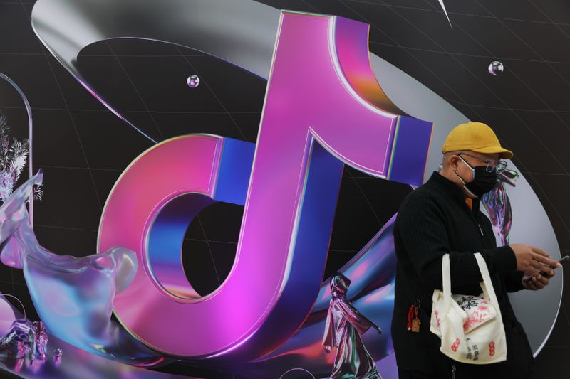 Man stands near a giant sign of Chinese company ByteDance’s