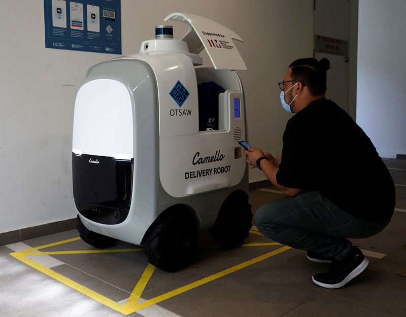 A customer collects his groceries from Carmello, an autonomous grocery