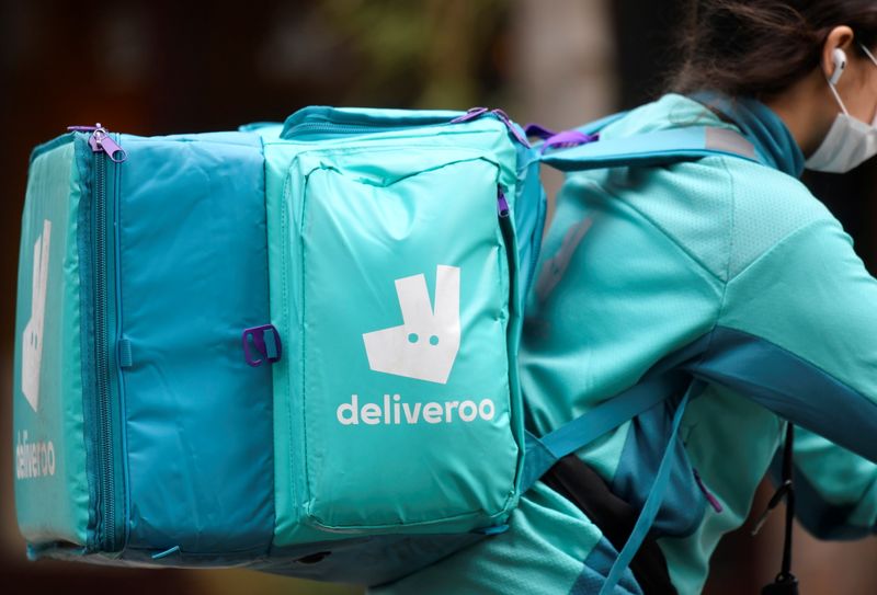 A Deliveroo delivery rider cycles in London