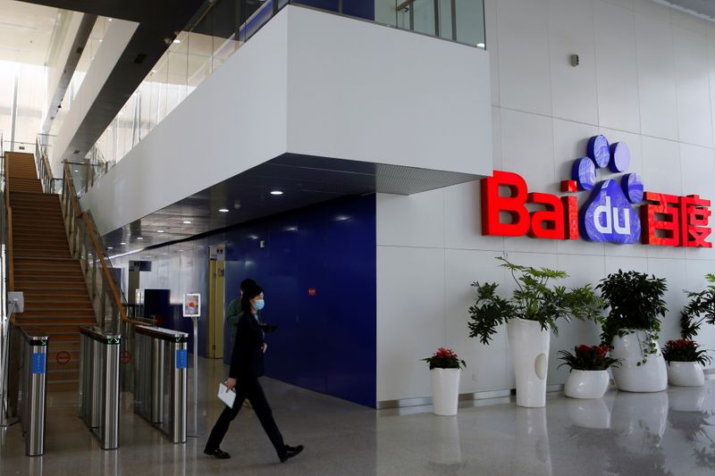 People walk near a Baidu logo at the company headquarters