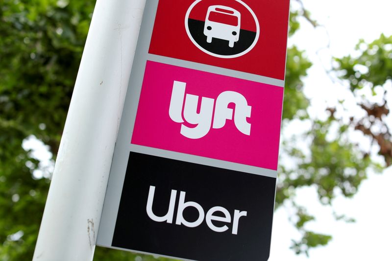 FILE PHOTO: The logos of Lyft and Uber are displayed