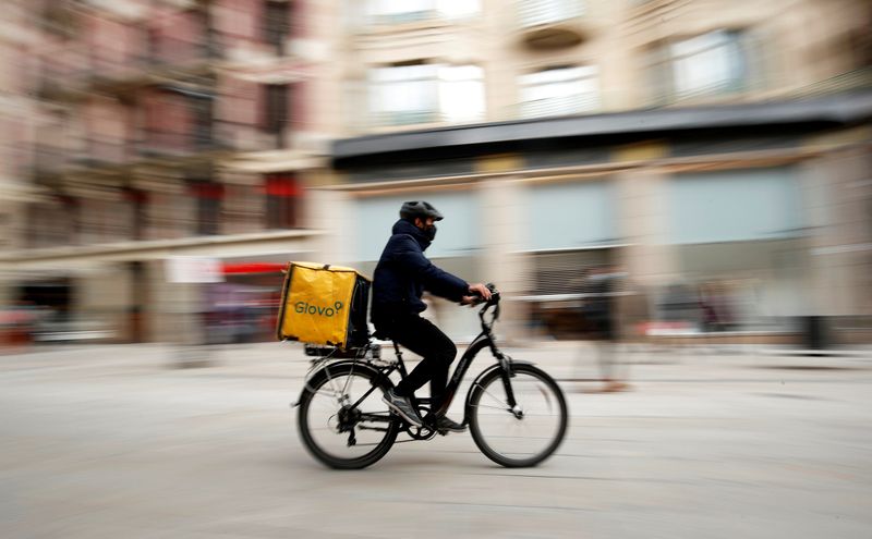 FILE PHOTO: Glovo deliver rider passes by a pedestrian area