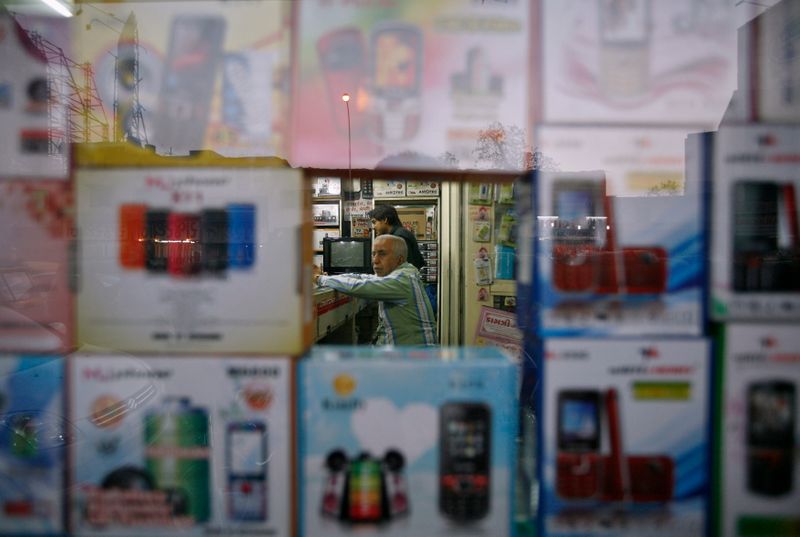 A vendor waits for customers inside his shop that sells