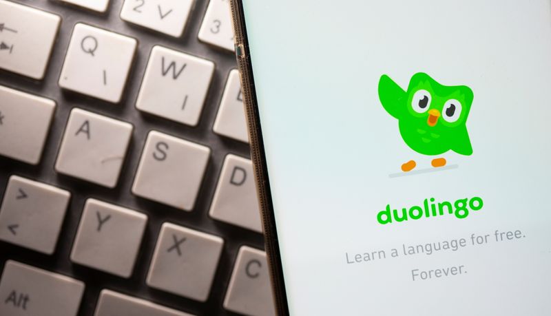Smartphone with displayed Duolingo app is placed on the keyboard