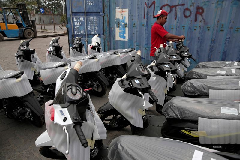 A worker prepares new motorcycles, which will be transported to