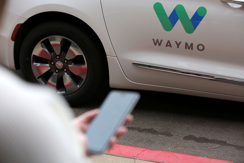 FILE PHOTO: A Waymo employee hails a ride on their