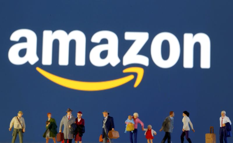 Small toy figures are seen in front of diplayed Amazon