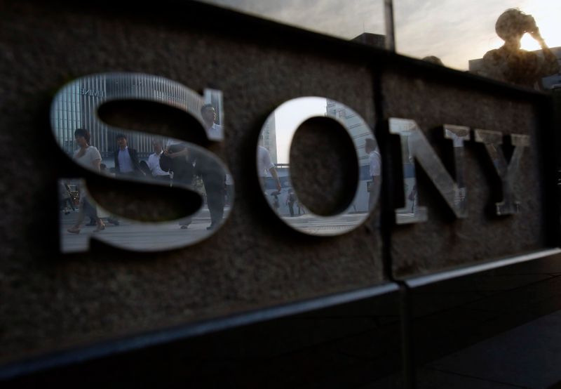FILE PHOTO: Pedestrians are reflected in a logo of Sony
