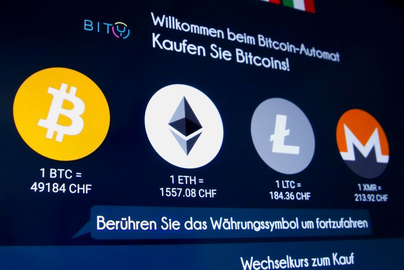 FILE PHOTO: The exchange rates and logos of Bitcoin, Ether,