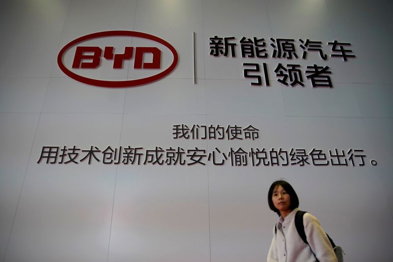 Woman walks past a BYD sign at the second media