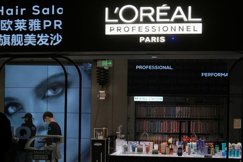 Staff members work at a hair salon of L’Oreal in