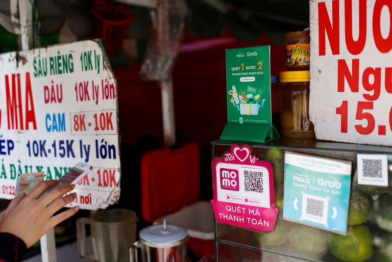 FILE PHOTO: Mobile e-payment logos are seen at a street