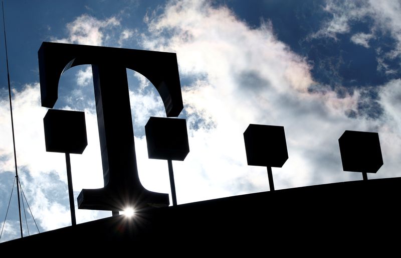 FILE PHOTO: A Deutsche Telekom sign silhouetted against the sun